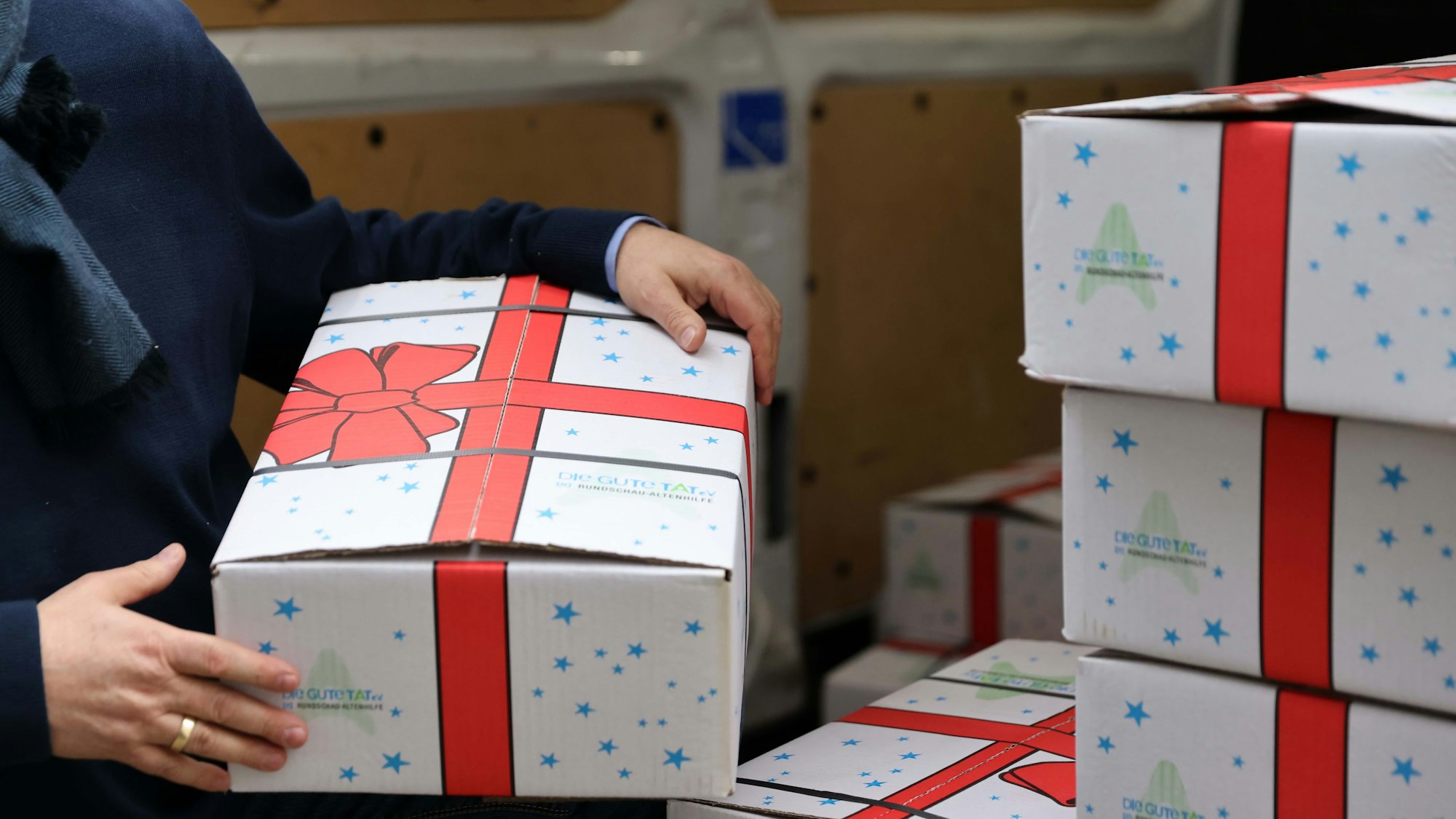 Viele freiwillige Helfer von Wohlfahrtsverbänden verteilen die Weihnachtspakete.