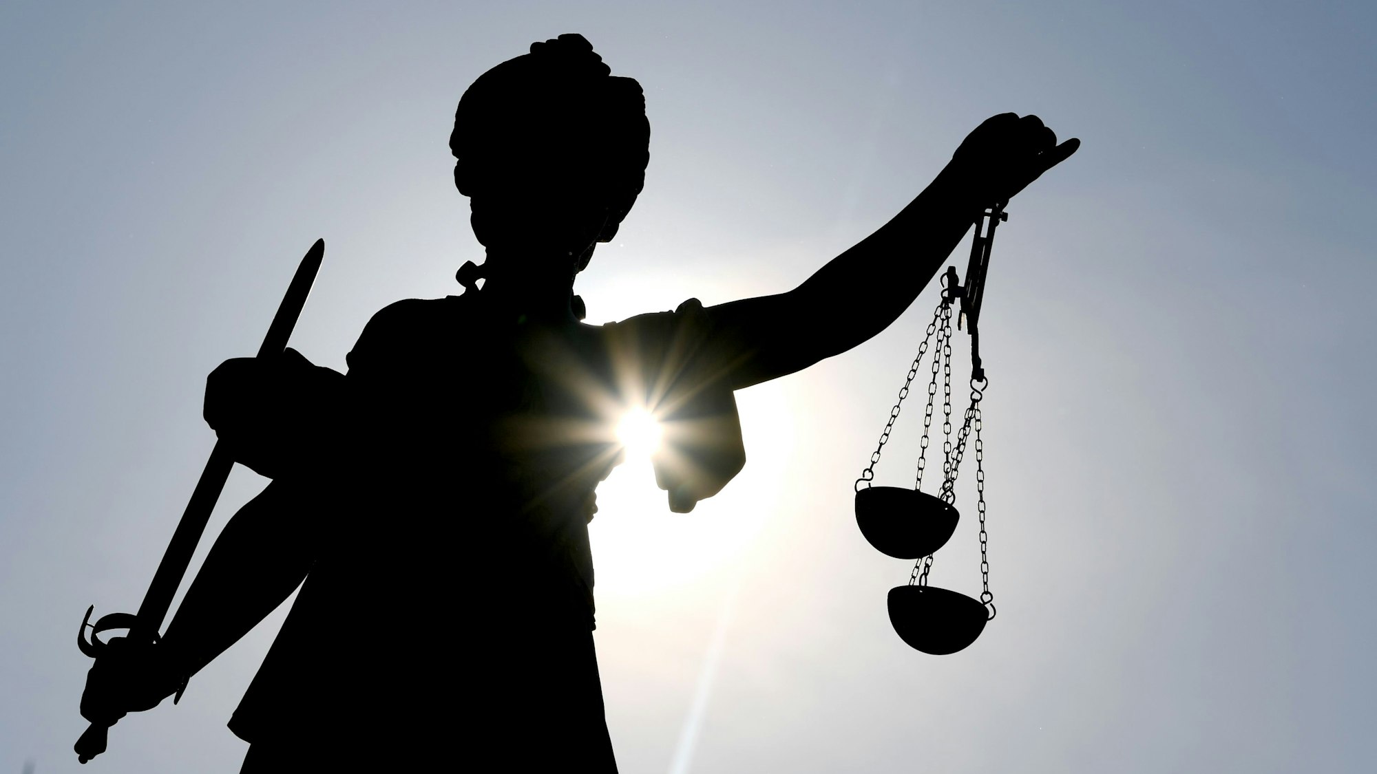 Die Statue der Göttin Justitia im Gegenlicht.