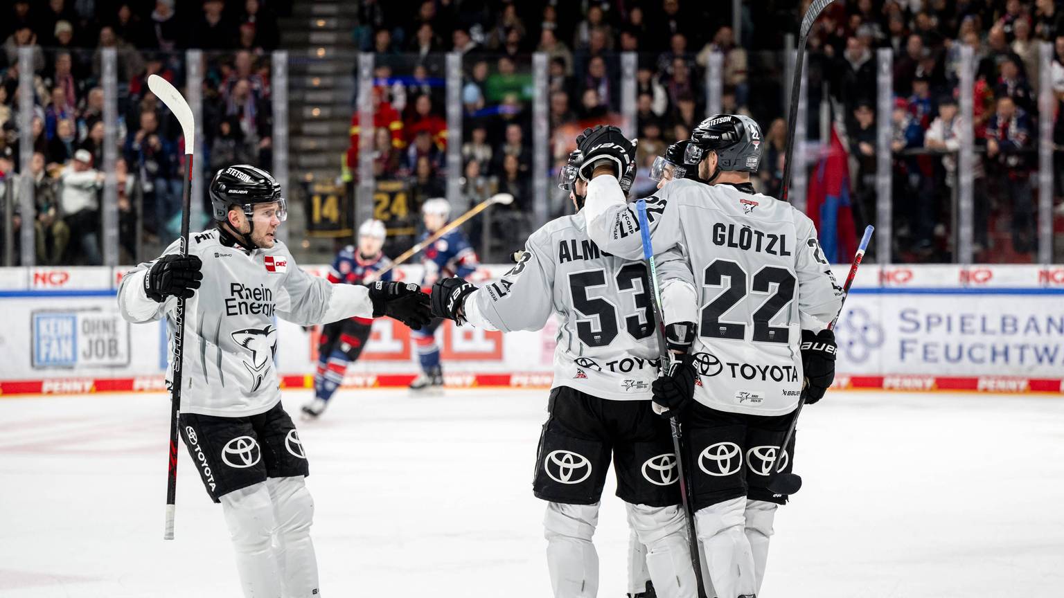 Die Haie-Spieler Parker Tuomie (l.) und Maximilian Glötzl (r.) freuen sich mit Torschütze Adam Almquist über das 1:1.