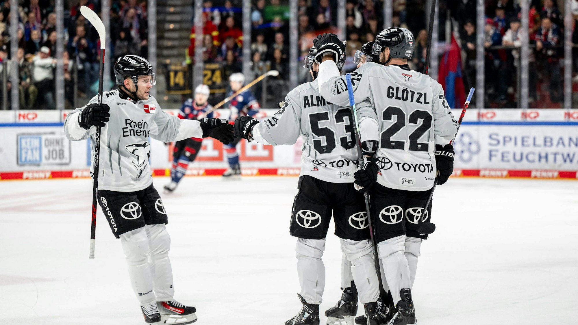 Die Haie-Spieler Parker Tuomie (l.) und Maximilian Glötzl (r.) freuen sich mit Torschütze Adam Almquist über das 1:1.