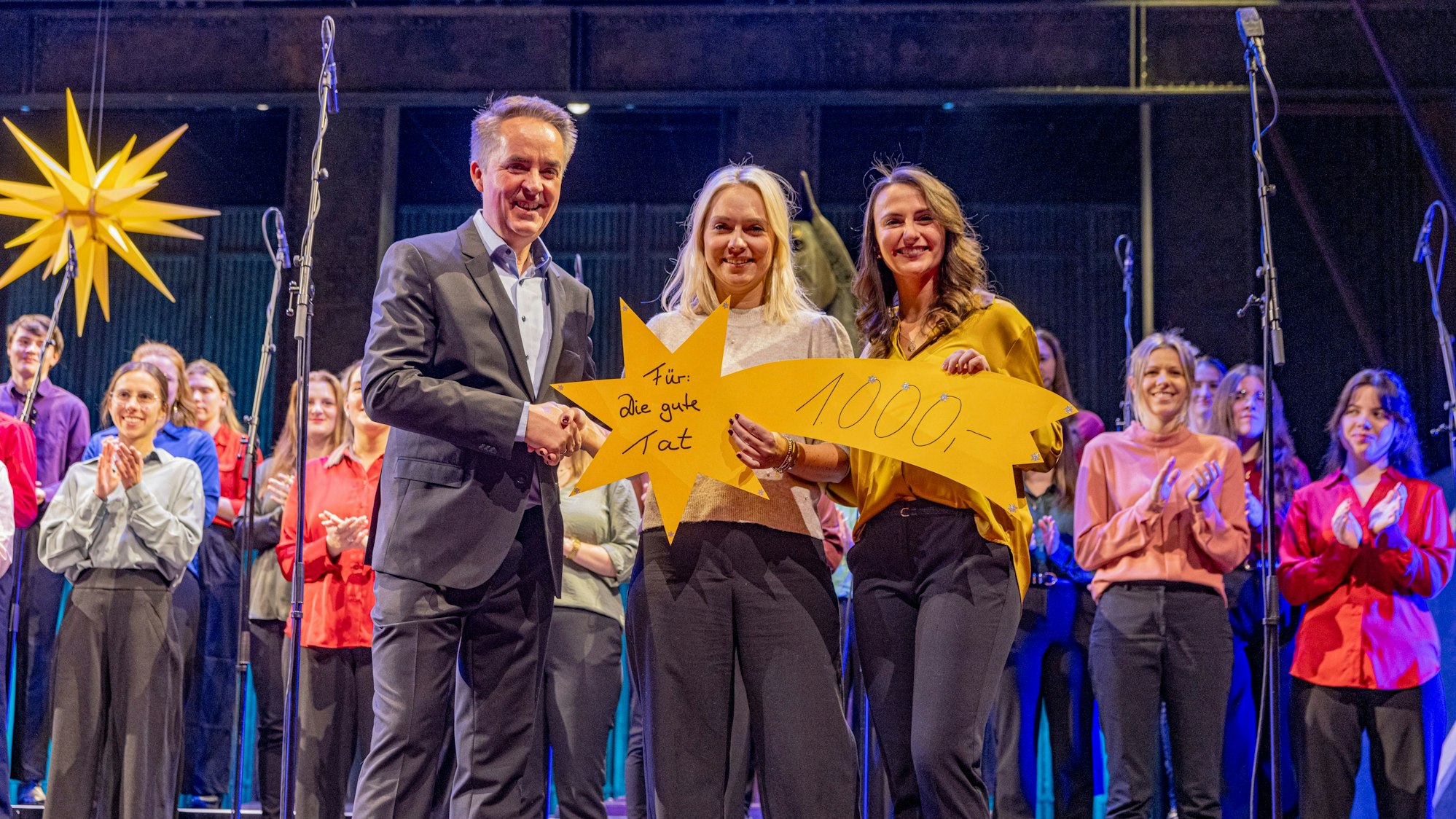 Spende mit Sternchen: 1000 Euro überreichten symbolisch Michael Kokott und Chormitglied Alina (rechts) an Julia Heinen.