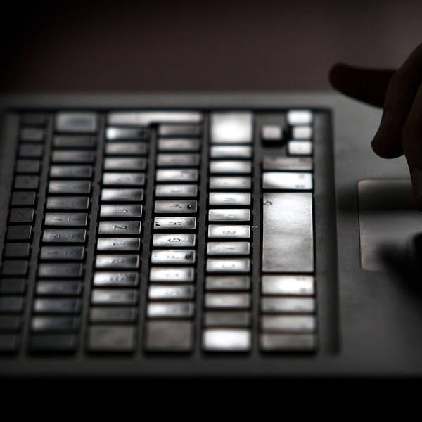 Eine Hand bedient einen Laptop.