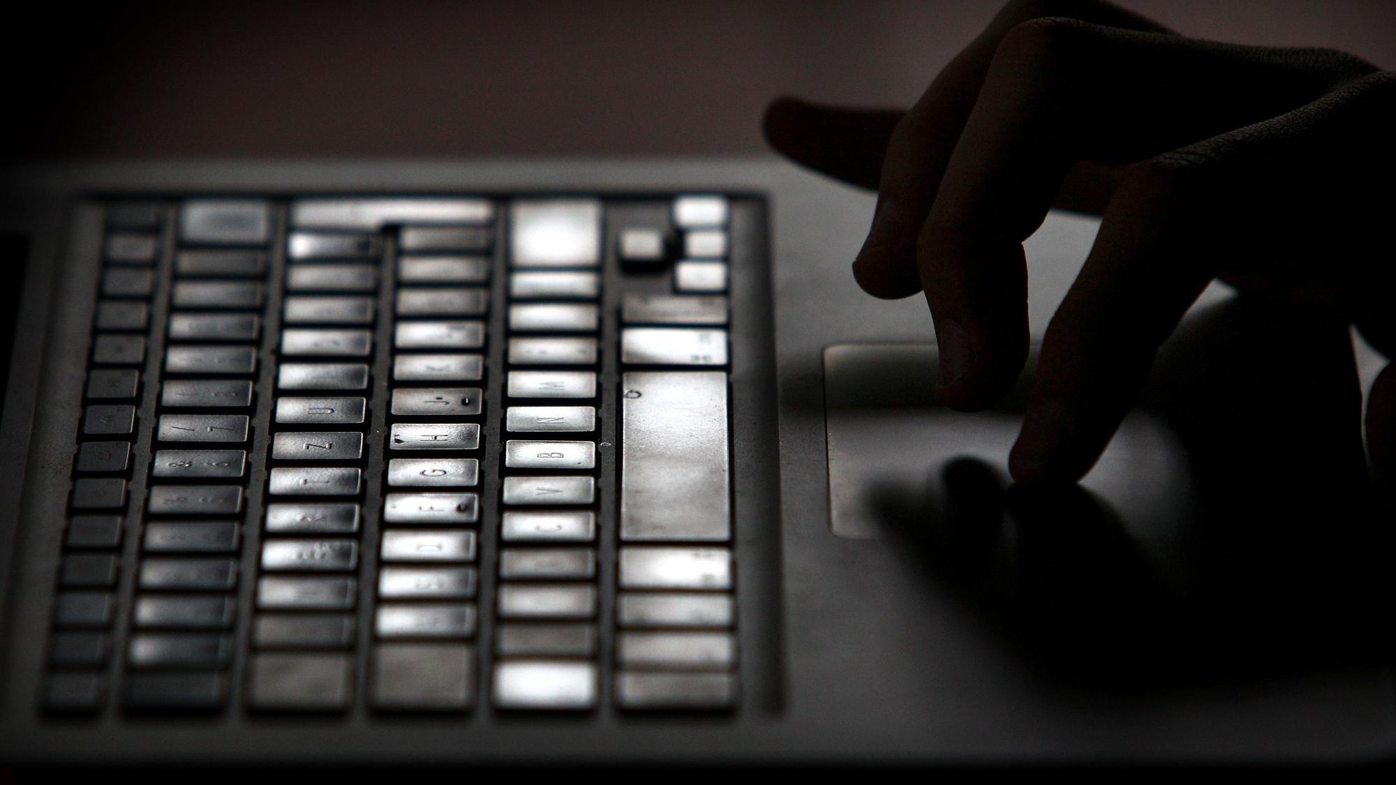Finger einer Person arbeiten an einem Laptop