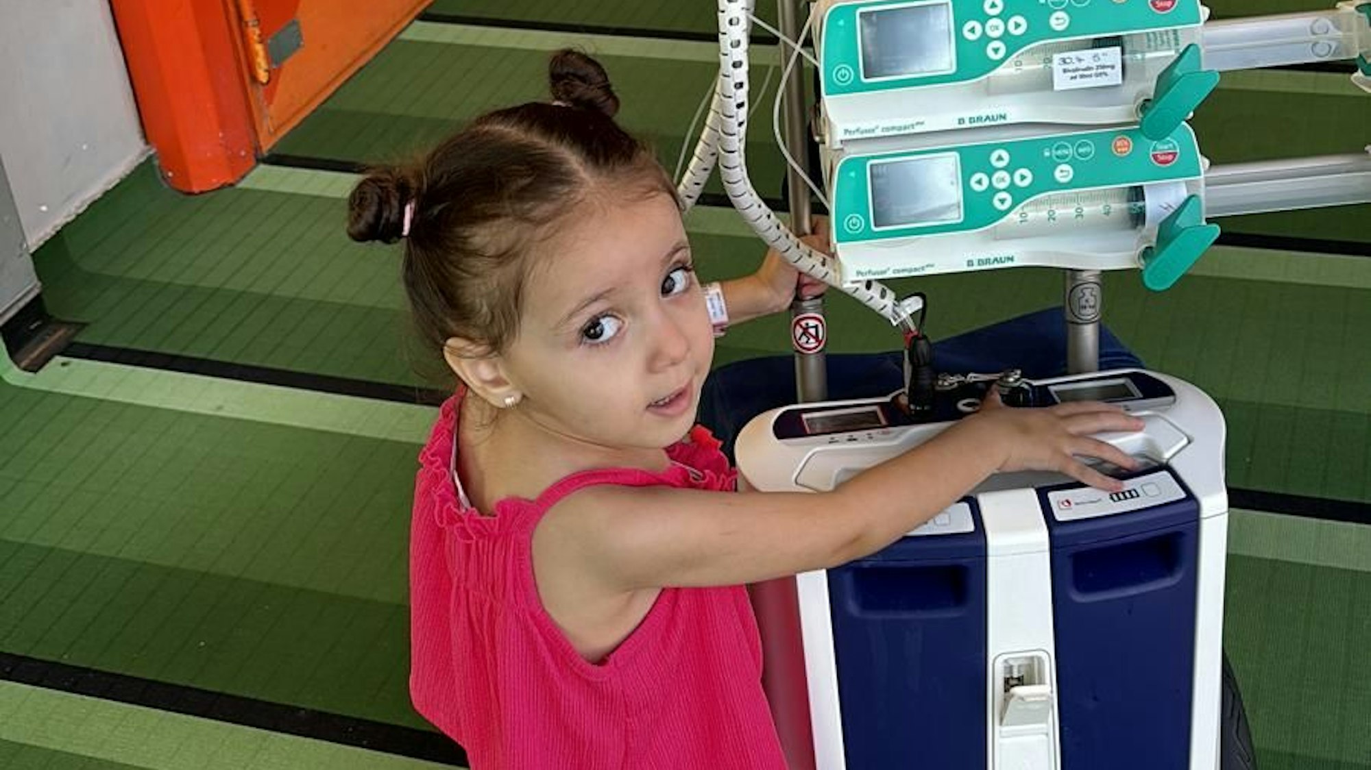 Das Foto zeigt ein kleines Mädchen, das an eine Herzmaschine angeschlossen ist.
