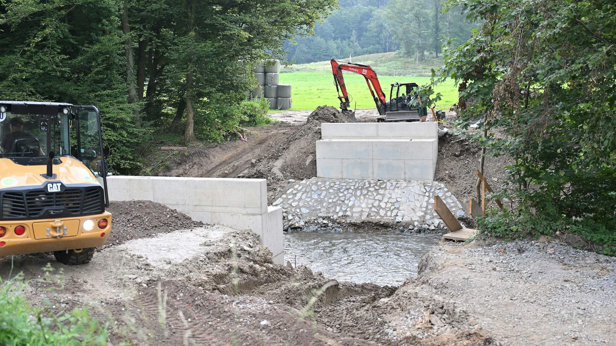 An einem Fluss wird eine Brücke gebaut.