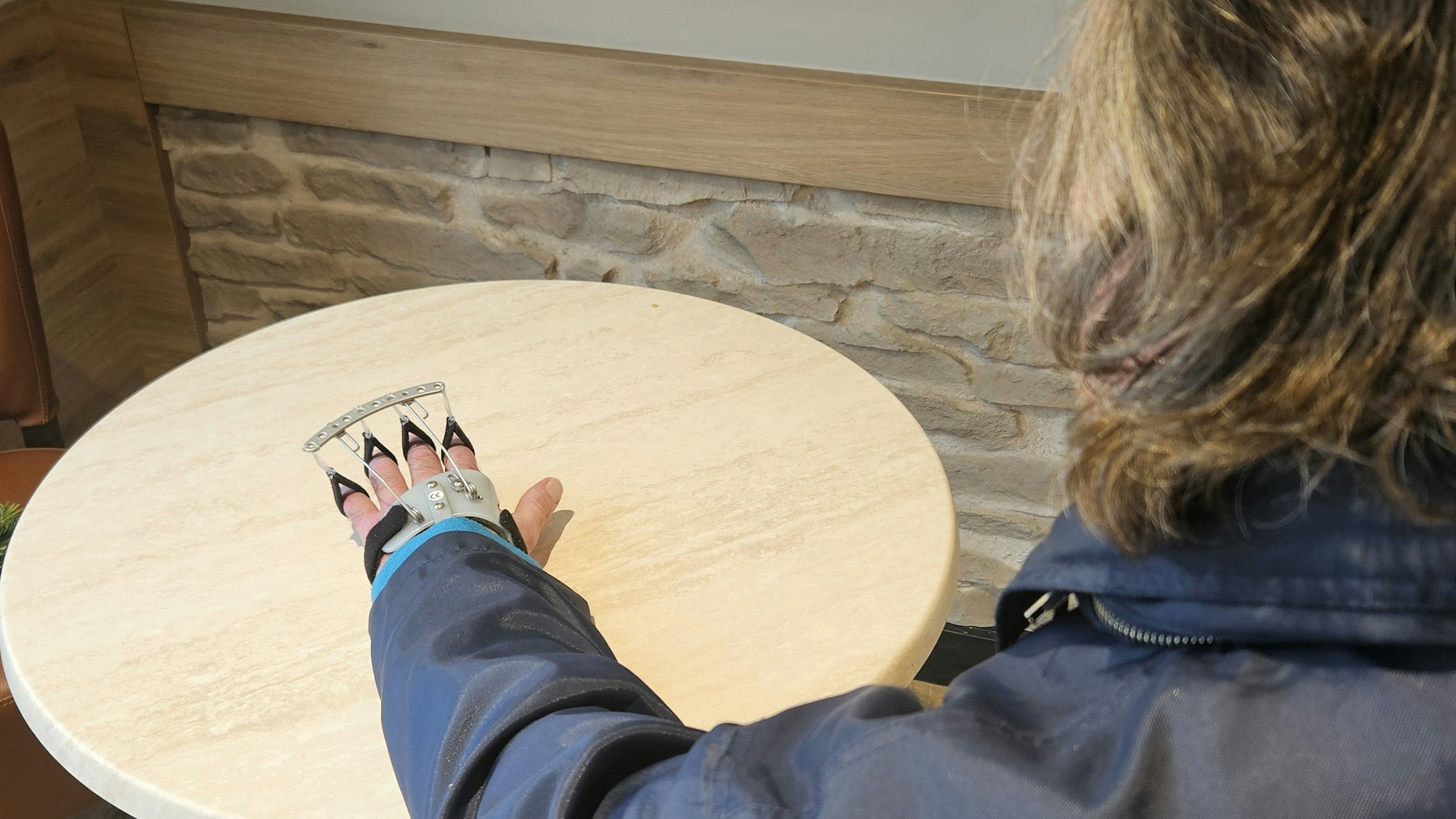 Foto von Ulrich G. von hinten. Die Orthese an der linken Hand ist zu sehen.