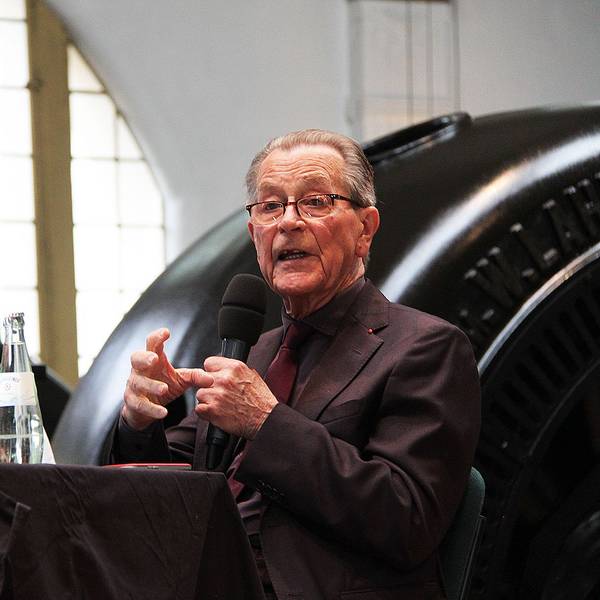 Franz Münterfering bei seiner Lesung im Jugendstilkraftwerk. Hinter ihm eine der mächtigen schwarzen Turbinen für die Energiegewinnung.