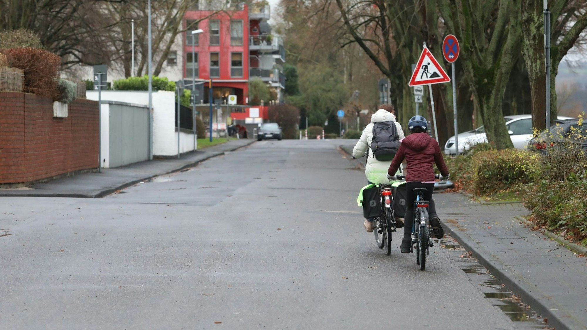 Zwei Radfahrer fahren hintereinander auf einer Straße.