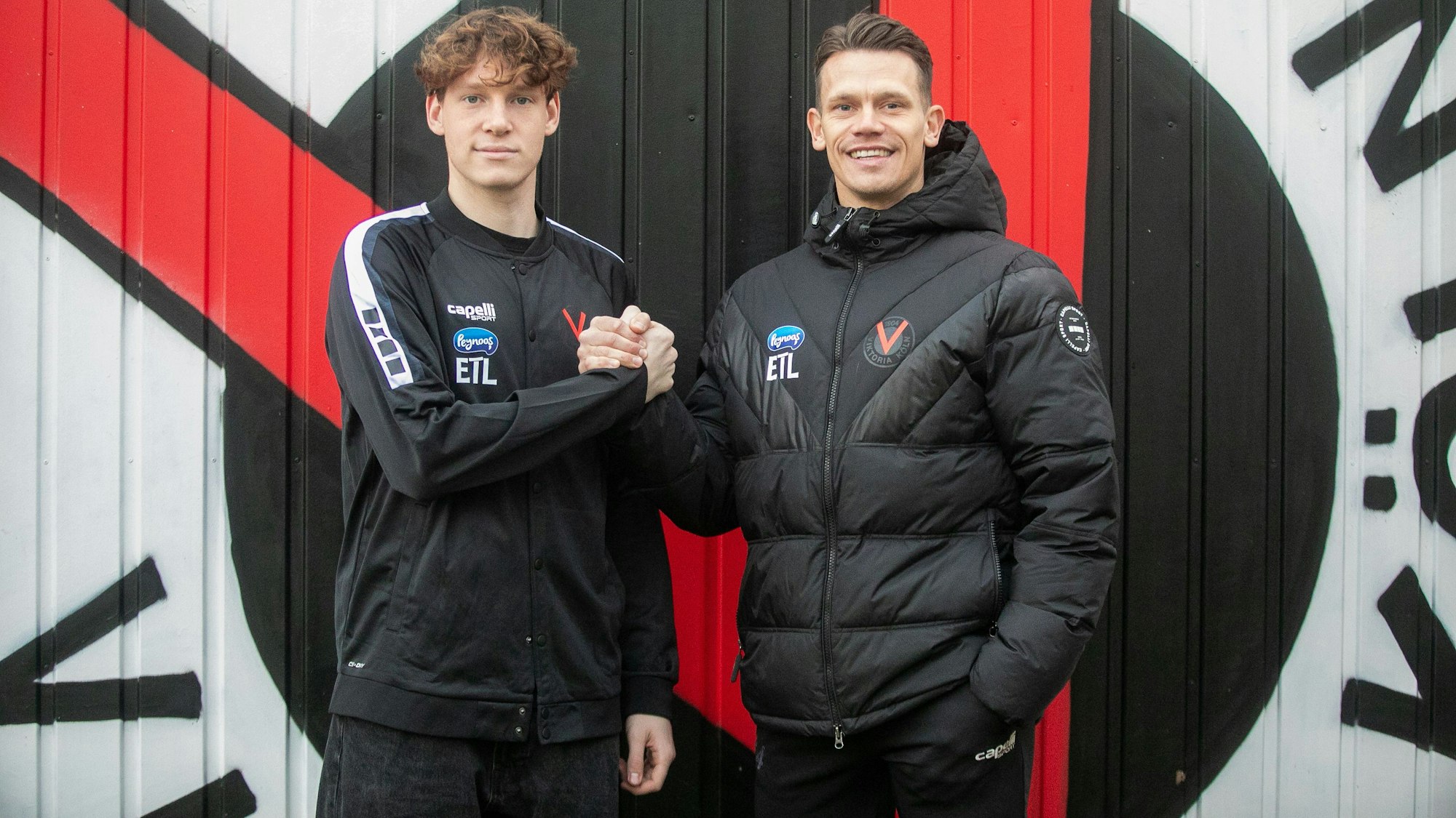 Oleksandr Petrenko unterschreibt und Vikotria Kölns Torwarttrainer Kevin Rauhut.