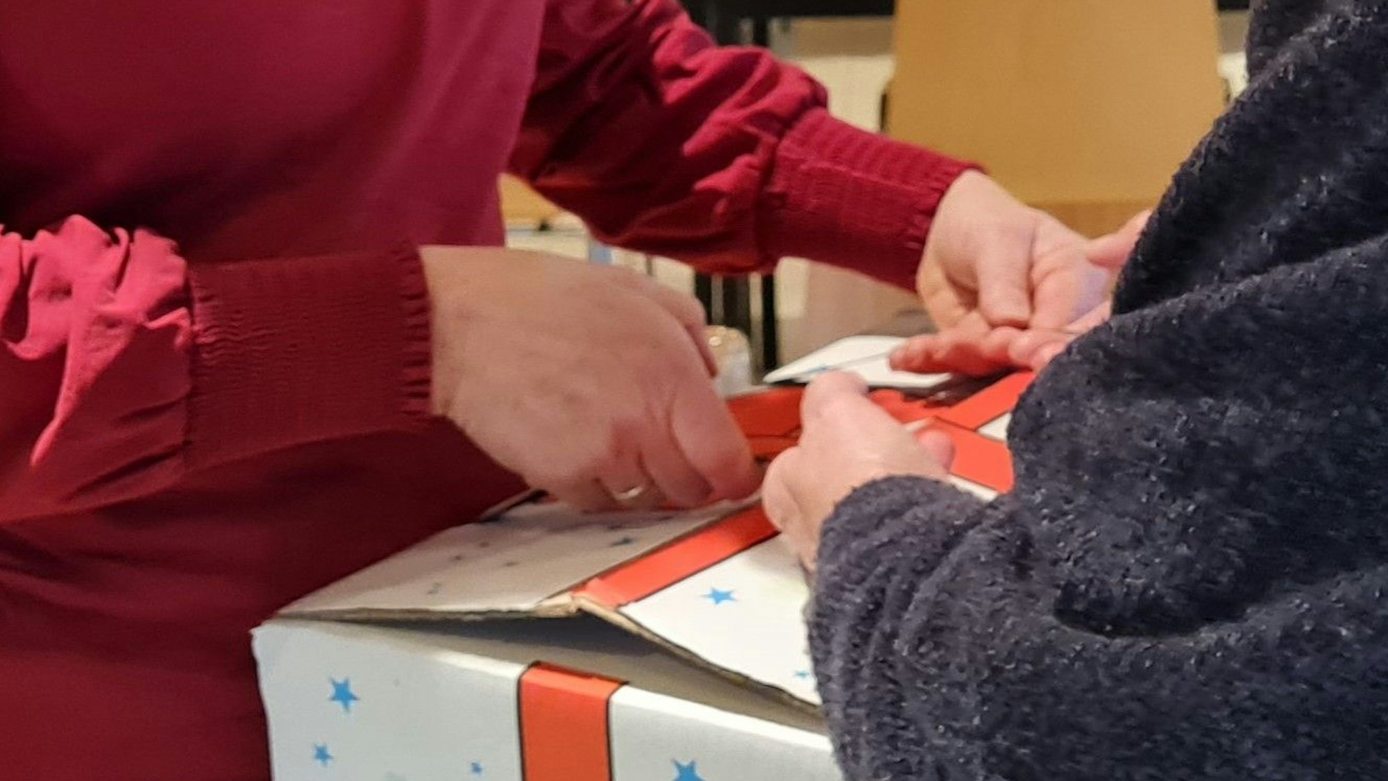 Durch viele Hände geht das Weihnachtspäckchen, bis es bei den Empfängern ankommt.