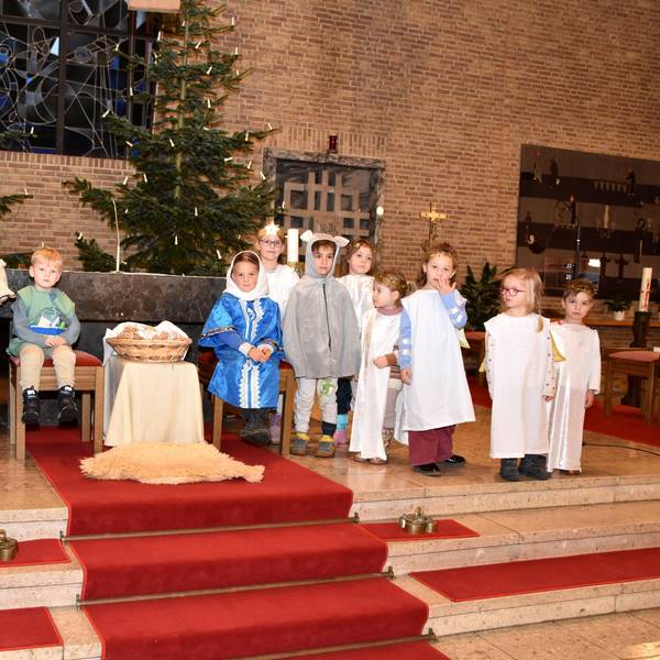 Das Foto zeigt die Kinder bei der Probe zum Krippenspiel vor dem Altar.