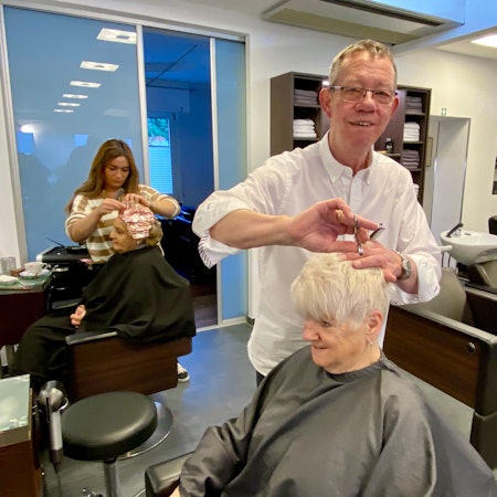 Zu sehen ist ein Friseur in einem Salon.