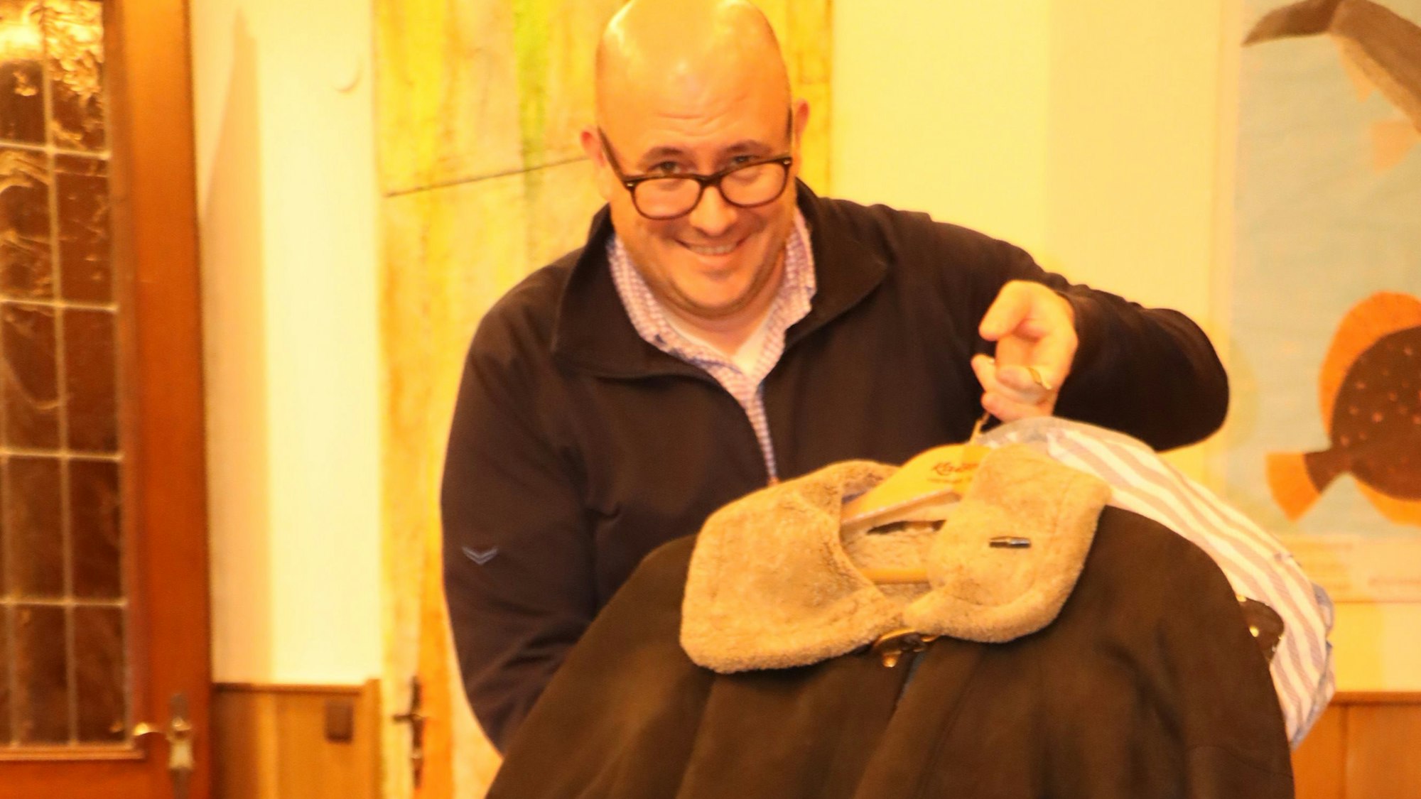 Peter Nettekoven zeigt gespendete Winterkleidung.