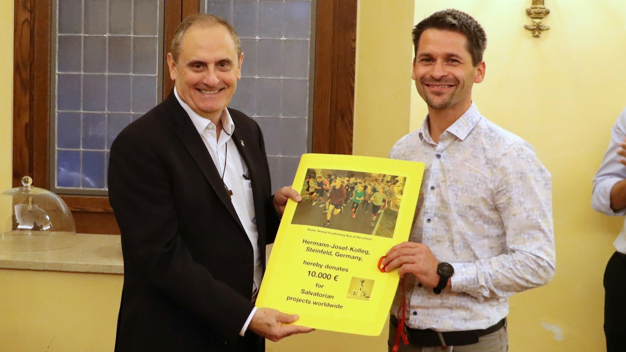Schulleiter Thomas Frauenkron bei der Übergabe des Schecks an Pater General Milton Zonta.