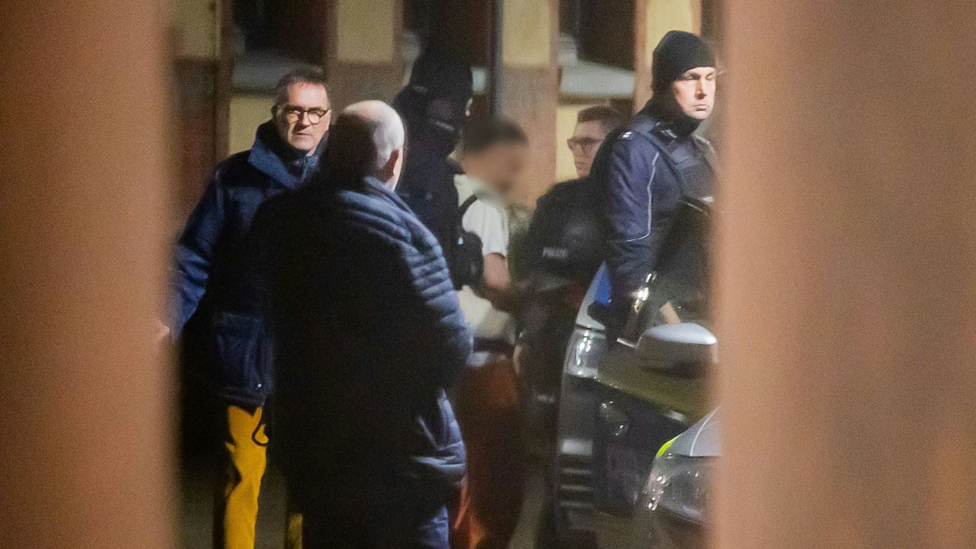 21.12.2024, Sachsen-Anhalt, Magdeburg: Eine Mann (M) wird im Beisein von Horst Walter Nopens (l), Leitender Oberstaatsanwalt Staatsanwaltschaft Magdeburg, im Innenhof des Justizzentrums zu einem Polizeifahrzeug geführt. Auf dem Weihnachtsmarkt in Magdeburg war am Vortag ein Autofahrer in eine Menschengruppe gefahren. Der Mann wurde festgenommen. Foto: Christoph Soeder/dpa - ACHTUNG: Mann aus rechtlichen Gründen gepixelt +++ dpa-Bildfunk +++