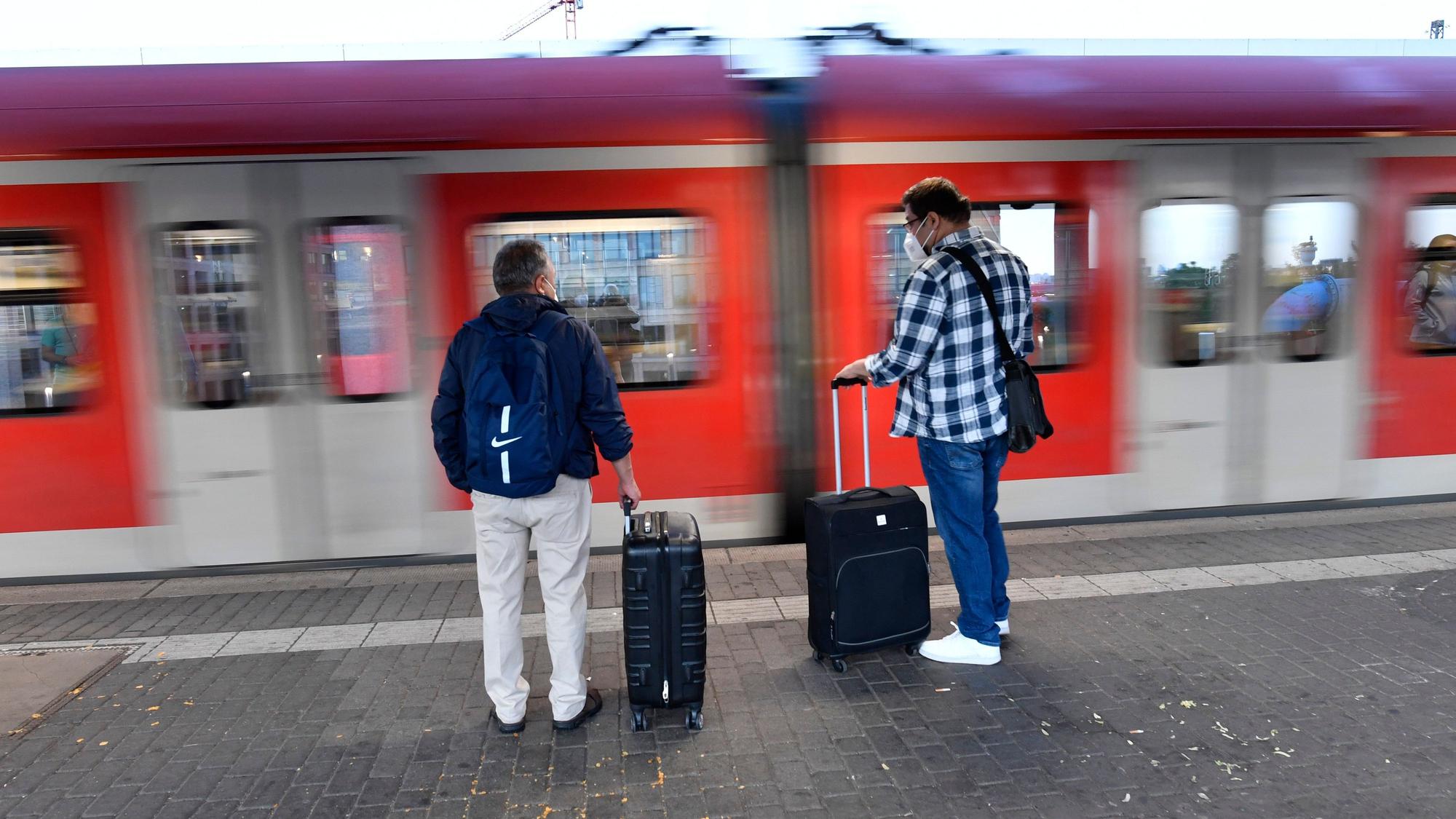 Reisende warten am Deutzer Bahnhof auf einen Zug.