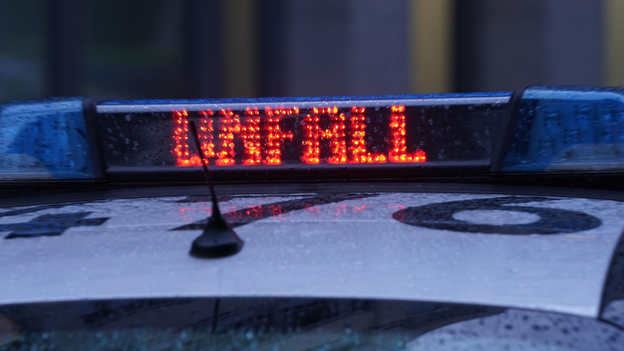 Der Schriftzug „Unfall“ ist neben dem Blaulicht auf dem Dach eines Polizeiautos zu lesen.