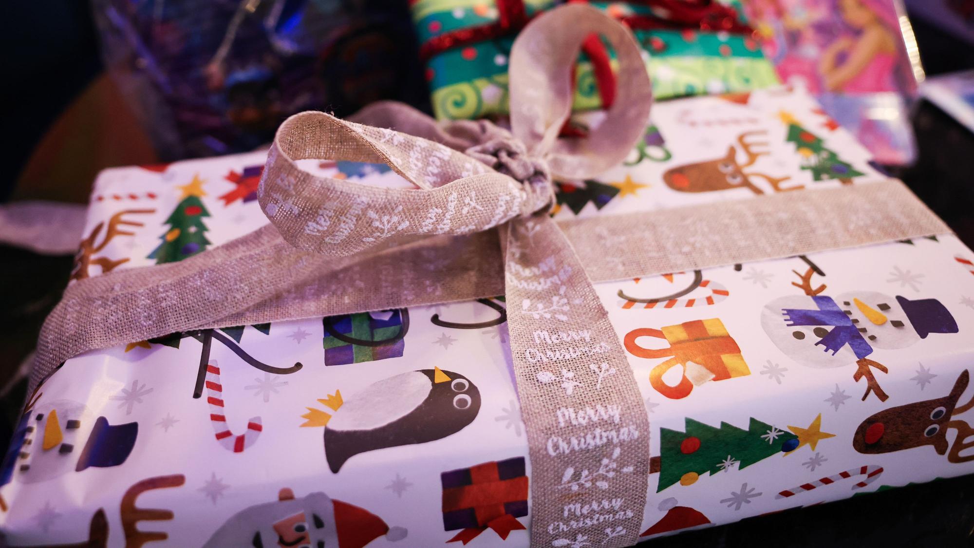 Weihnachtlich verpackte Geschenke liegen auf einem Tisch.