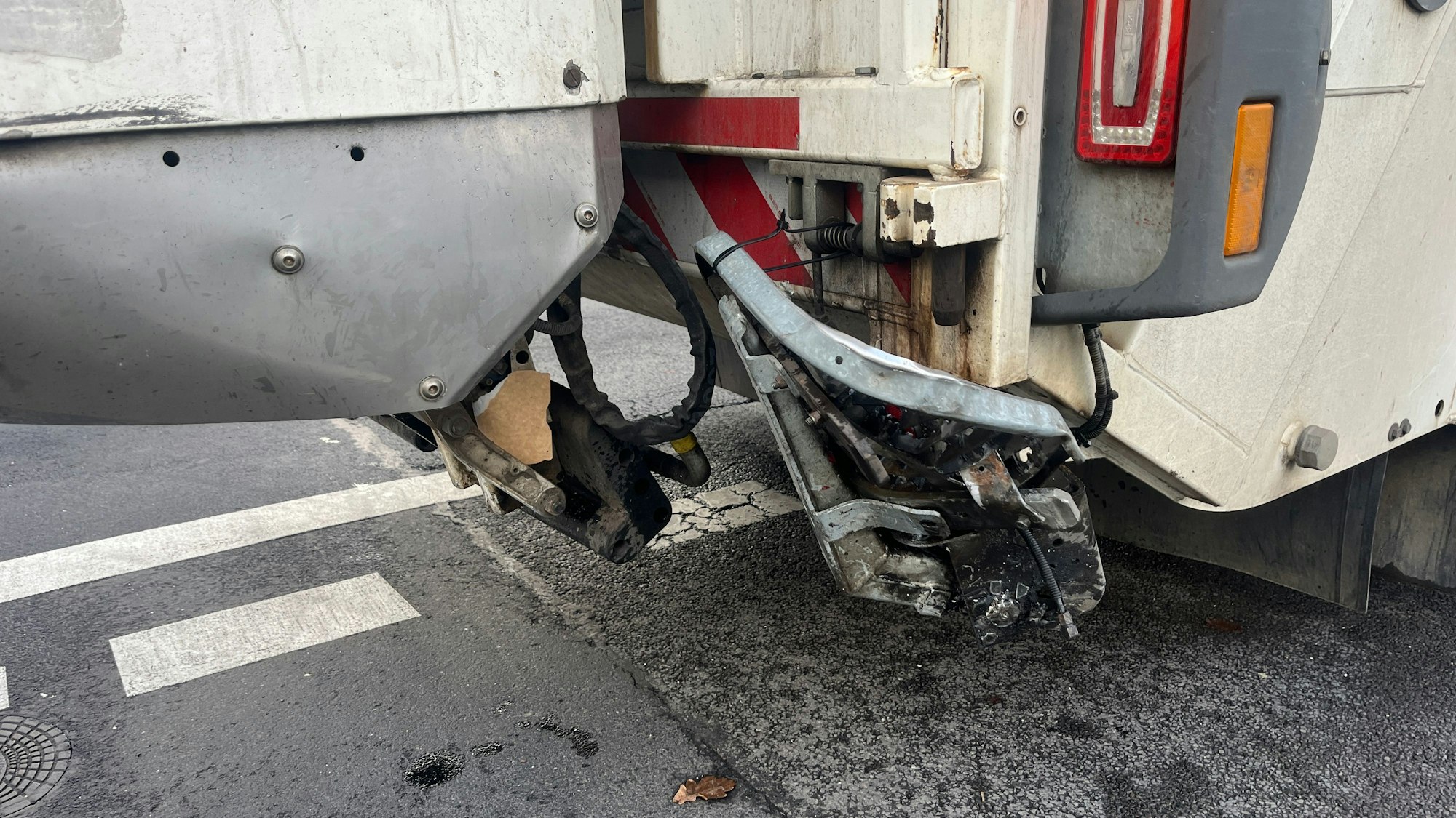 Die Trittstufe eines Müllautos ist nach einem Unfall nach oben gebogen.
