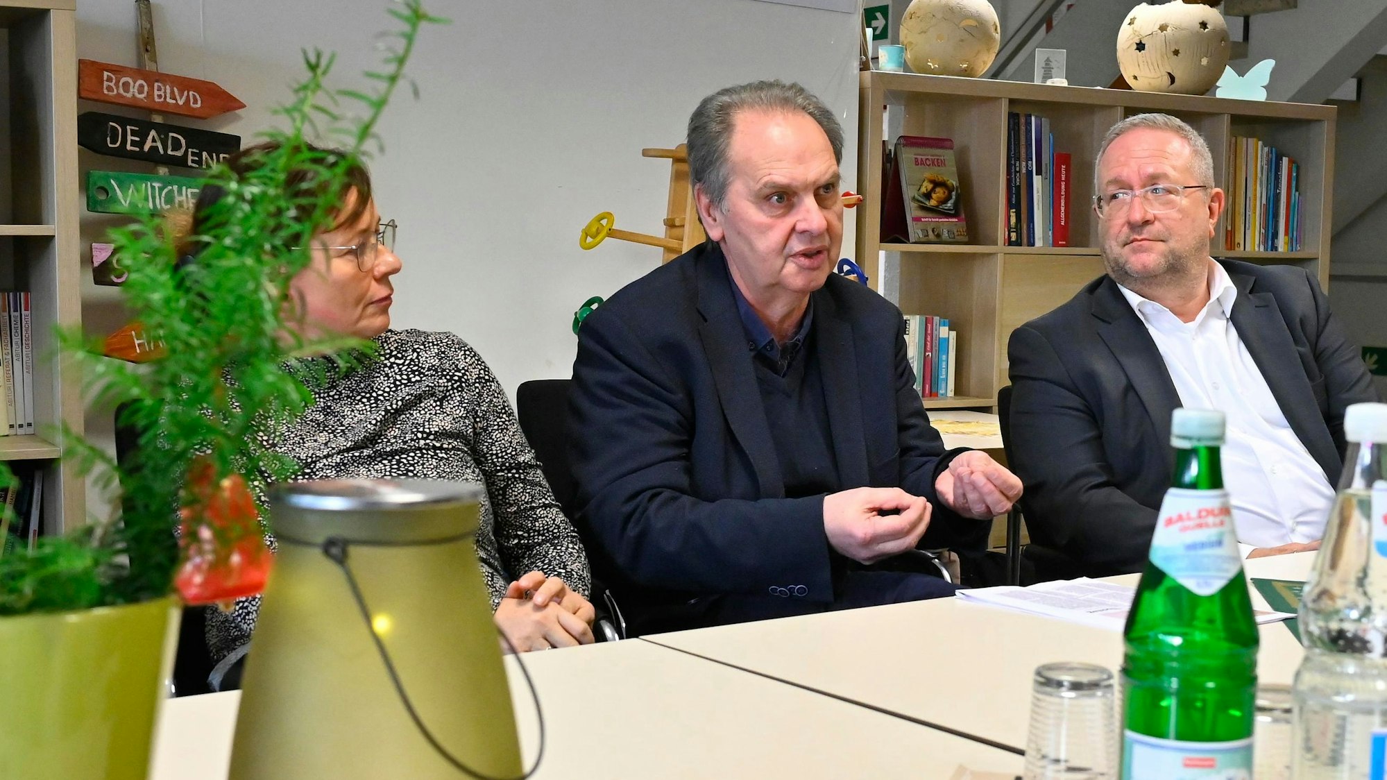 Ein Mann sitzt an einem Tisch und erklärt.