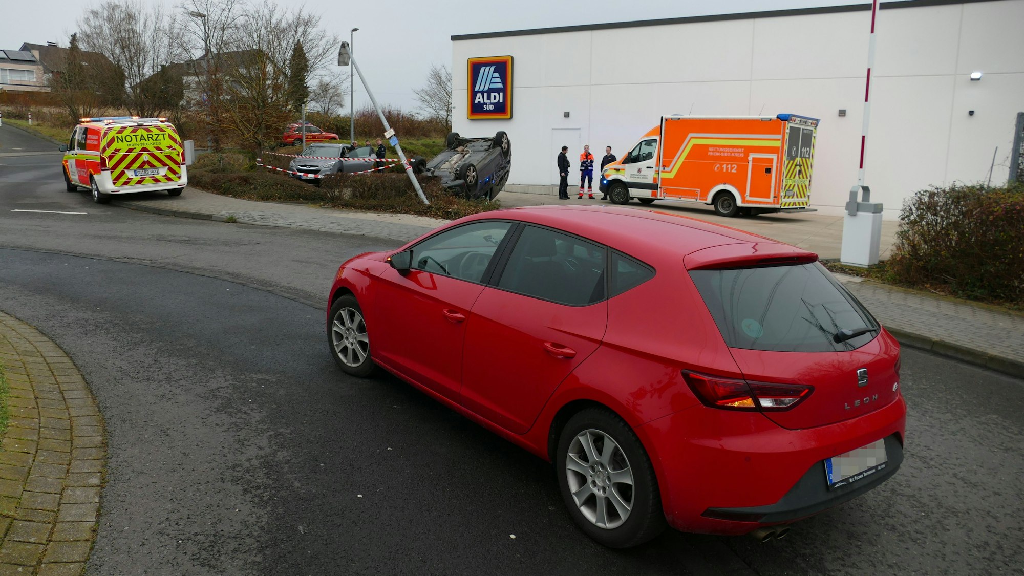 Ein rotes Auto steht in einem Kreisverkehr.