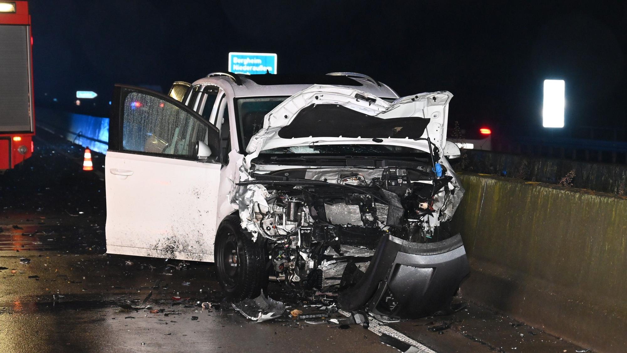 Ein weißes, schwer zerstörtes Auto steht auf der Fahrbahn.