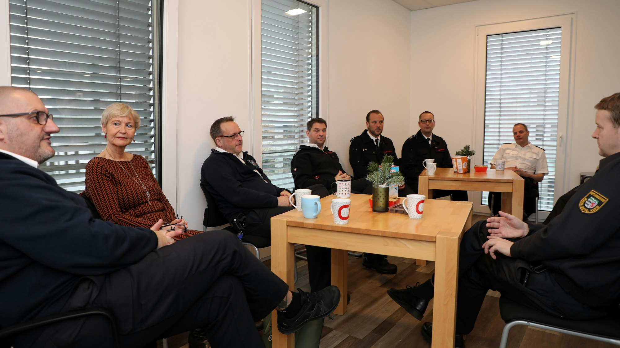 Dezernentin Annette Kupferschmidt-Fritz und Vertreter der Feuerwehren aus Rösrath, Overath und Kürten sowie Odenthal sitzen zusammen und tauschen sich aus.