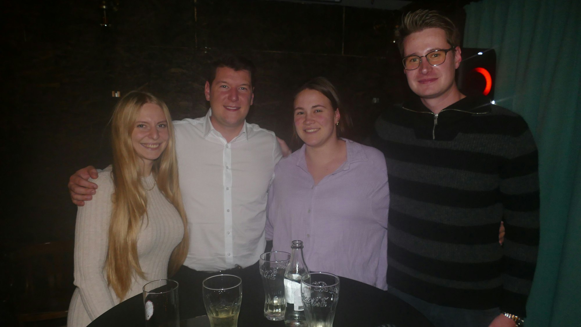 Junge Leute an einem Stehtisch in einer Gaststätte.