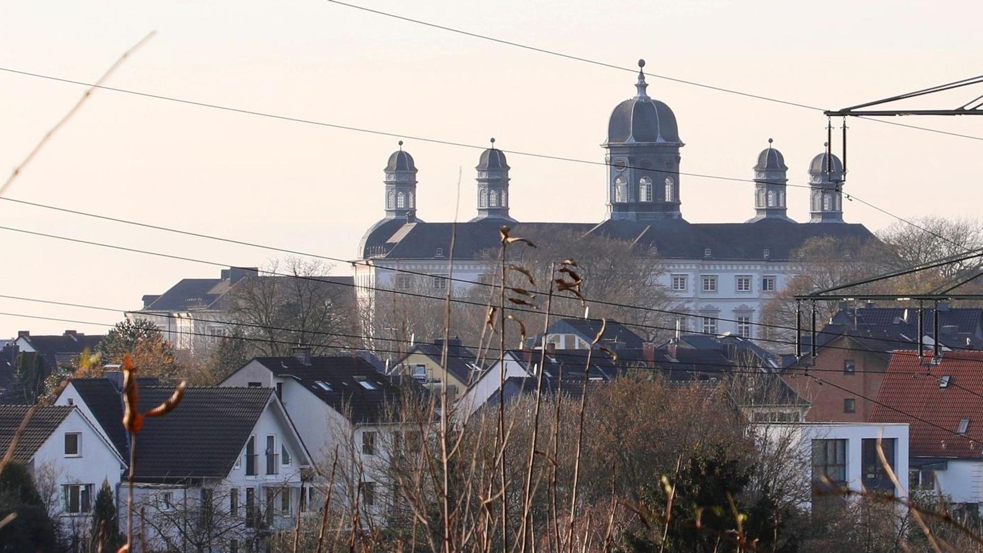 Am Horizont ist das Barockschloss von Bensberg zu sehen.