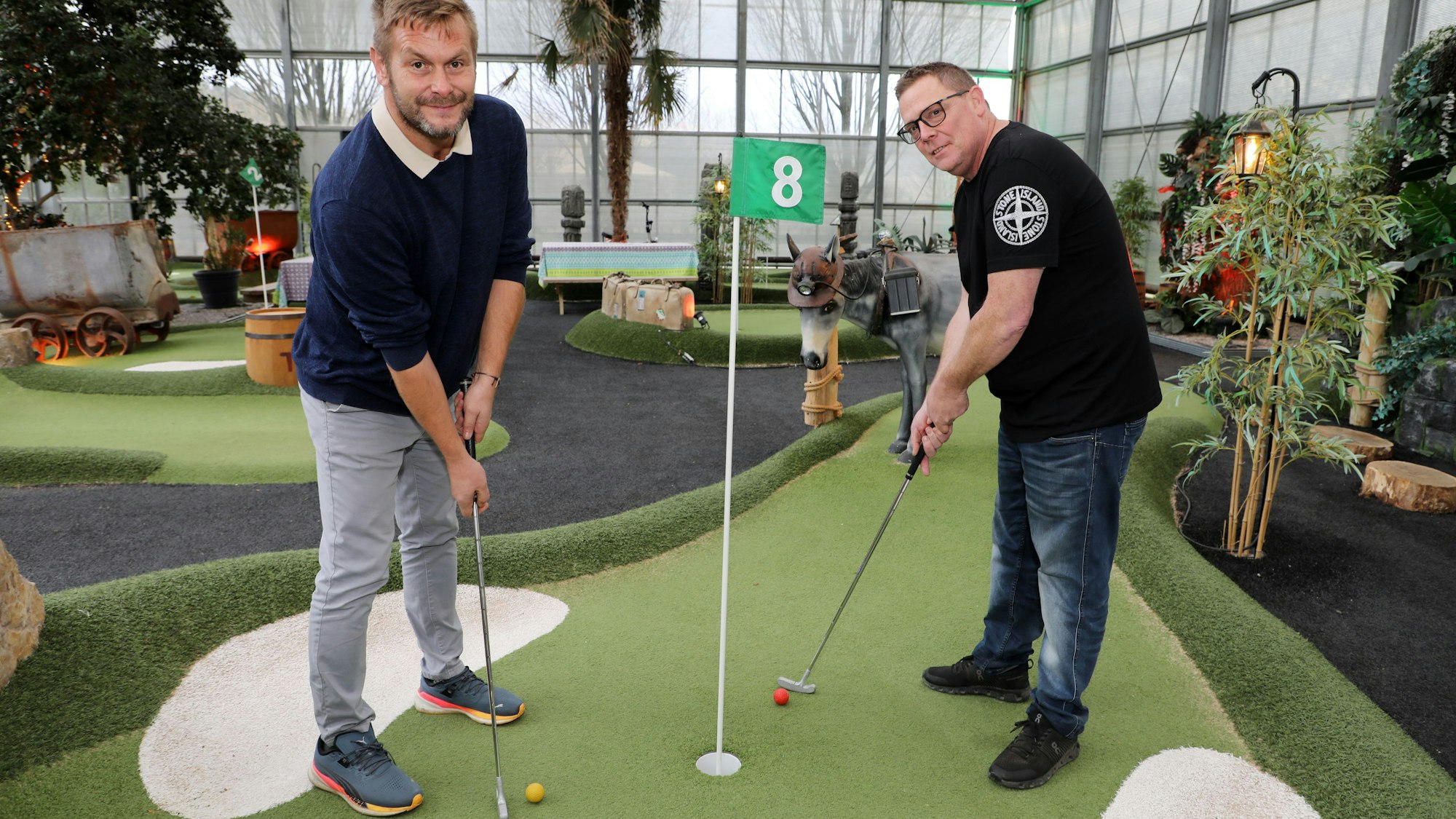 Norbert Peters (r.) und Ralf Fritz stehen mit Minigolfschlägern in Adventure-Minigolf-Halle auf dem Lüderich bei Overath-Stenenbrück.