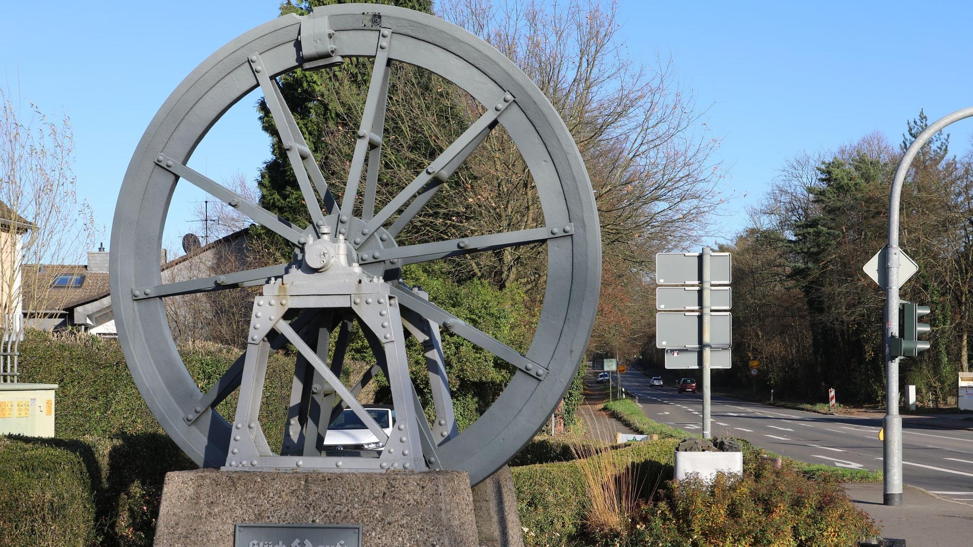 An der Kreuzung in Bergisch Gladbach-Moitzfeld steht eine Seilscheibe des ehemaligen Bergwerks Grube Weiß.