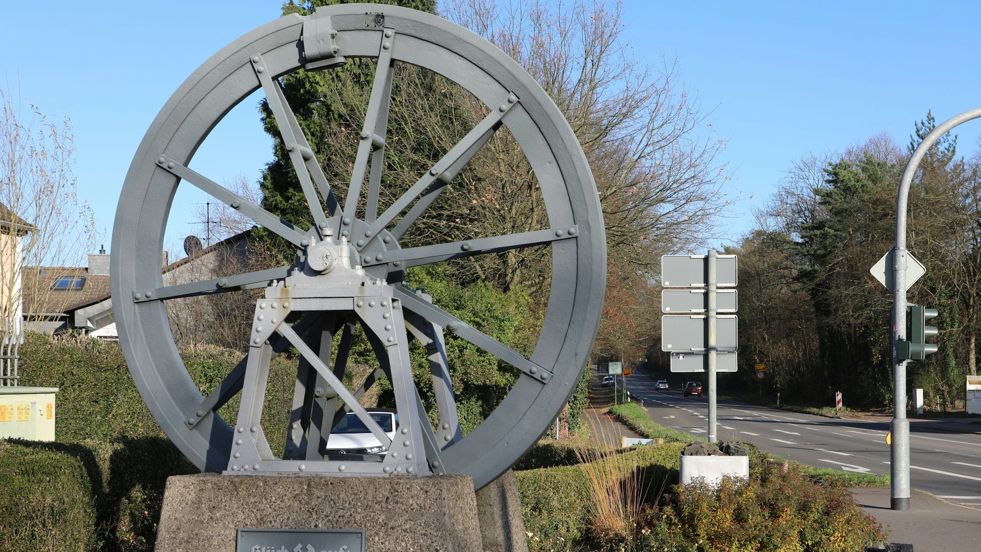 An der Kreuzung in Bergisch Gladbach-Moitzfeld steht eine Seilscheibe des ehemaligen Bergwerks Grube Weiß.