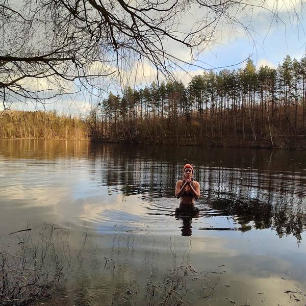 Zu sehen ist Janna Schillinger, die in das Wasser eines winterlichen Sees eintaucht.