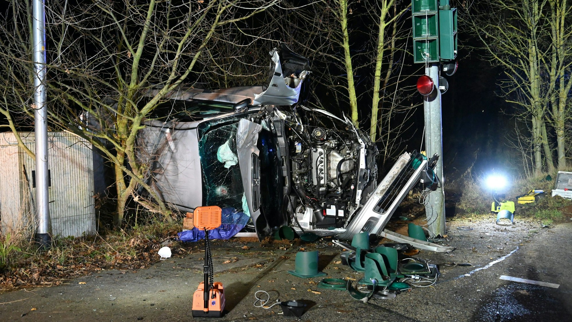 Ein zerstörtes Auto liegt an einem Baum.