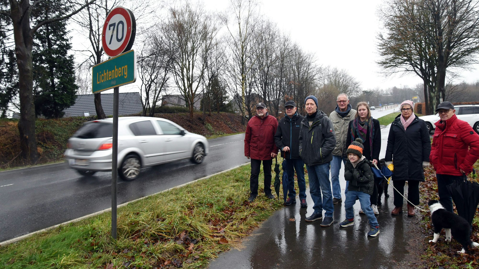 Auf weiten Teilen der Landesstraße 324 in Morsbach-Lichtenberg soll Tempo 70 gelten, damit der Verkehr auf der stark befahrenen Straße weniger Lärm macht. Das fordern Johannes Schlechtingen (3. von links) und seine Mitstreiter jetzt in einer Petition für ihren Wohnort. Unser Foto zeigt die Gruppe am Straßenrand