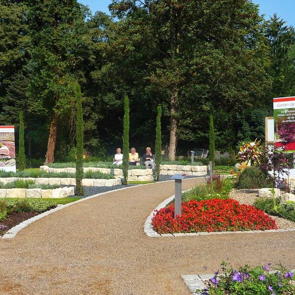 Blick auf eine gepflegte gartenähnliche Grabanlage mit blühenden Blumen