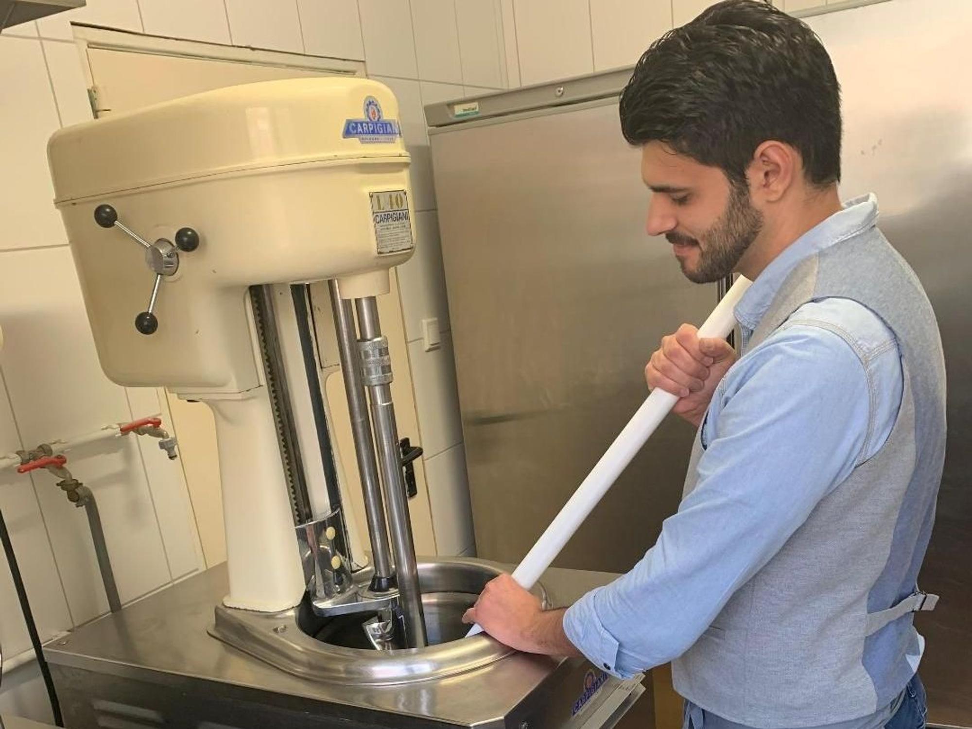 Ein Mann steht an einer Eismaschine.
