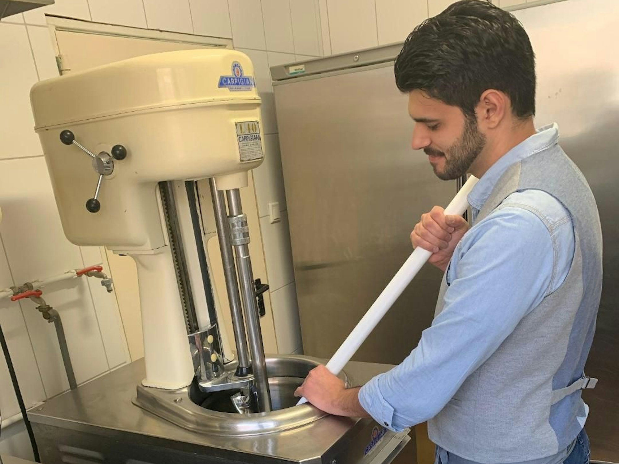 Ein Mann steht an einer Eismaschine.