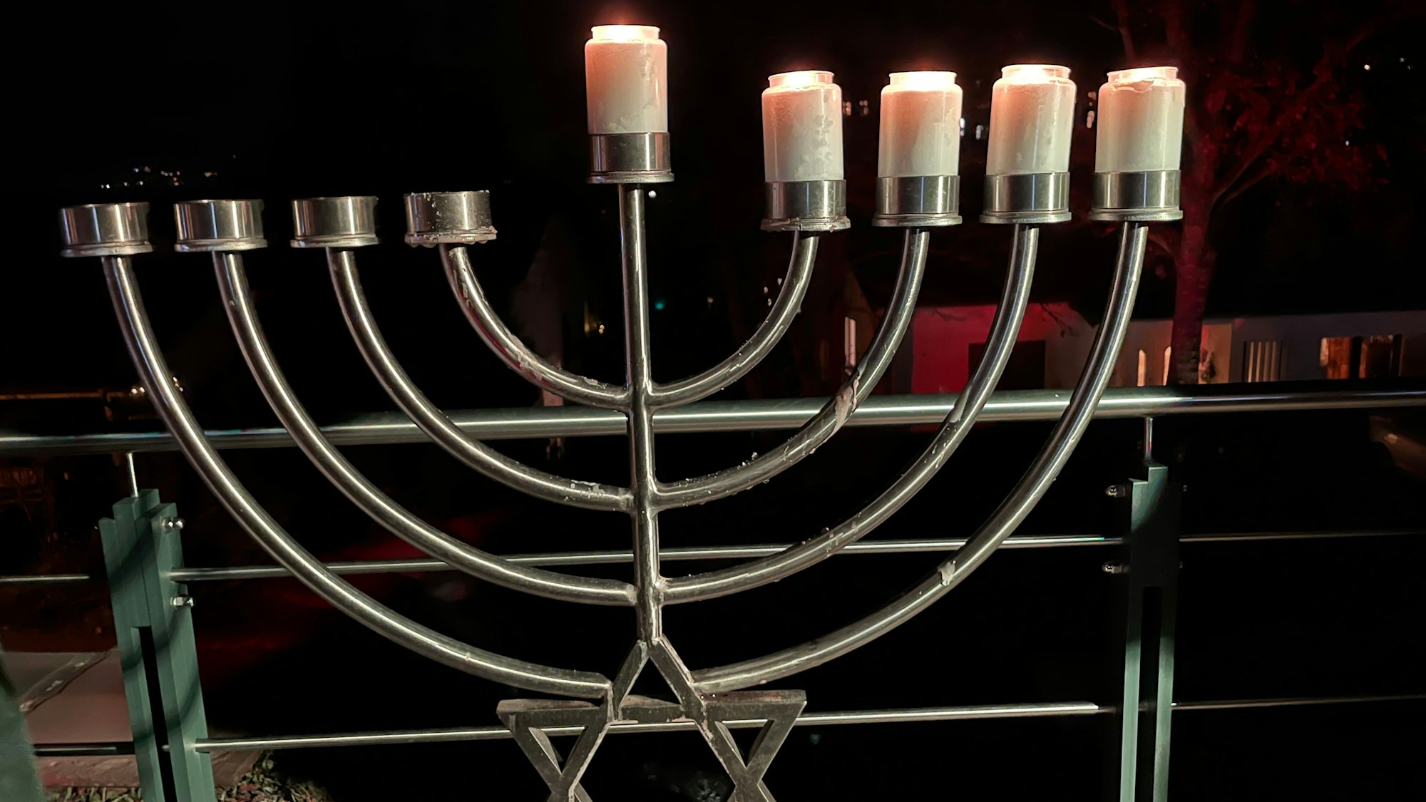 Fünf Kerzen brennen auf einem neunarmigen Leuchter.