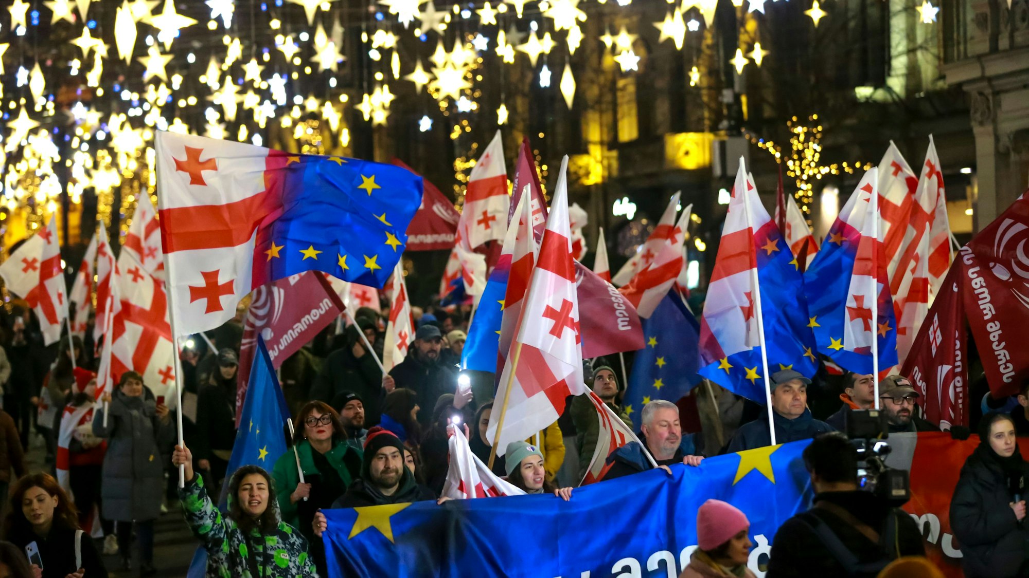dpatopbilder - 28.12.2024, Georgien, Tiflis: Demonstranten mit georgischen National- und EU-Fahnen nehmen an einer regierungskritischen Kundgebung vor dem Parlamentsgebäude teil.