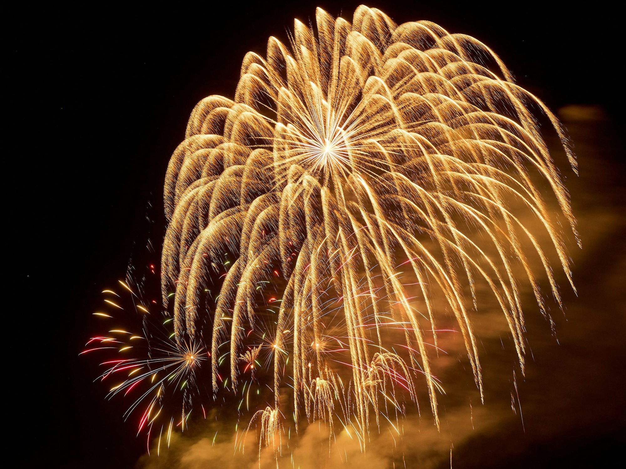 Das Foto zeigt Ein Feuerwerk am nächtlichen Himmel.