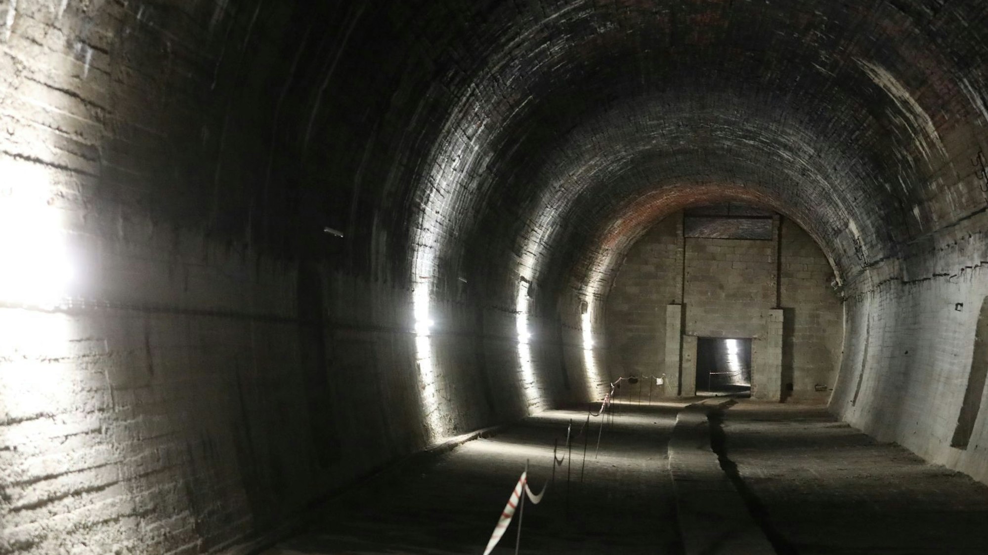 Blick in einen lange, nur spärlich beleuchtete Tunnelröhre.