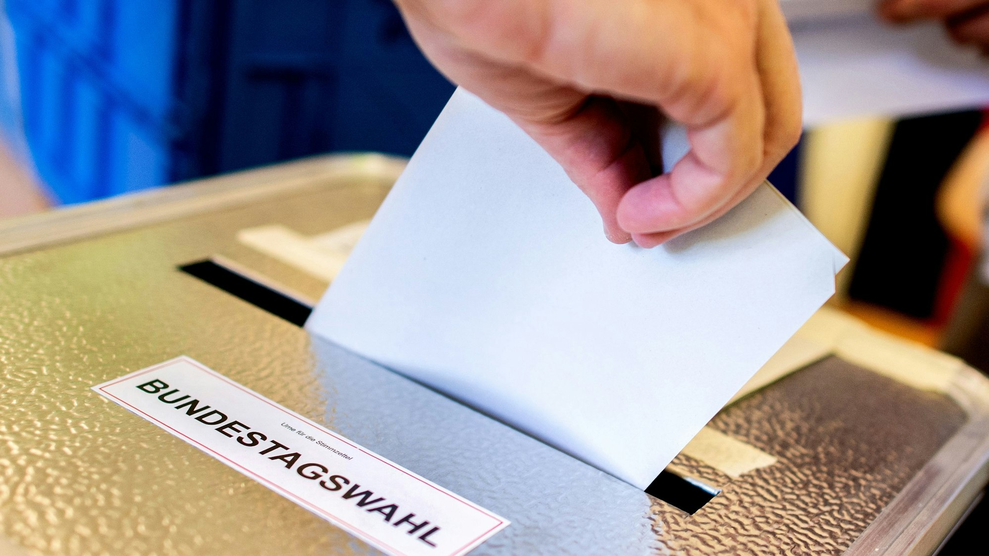Ein Wähler wirft in einem Wahllokal seinen Stimmzettel für die Bundestagswahl in eine Wahlurne (Symbolbild).