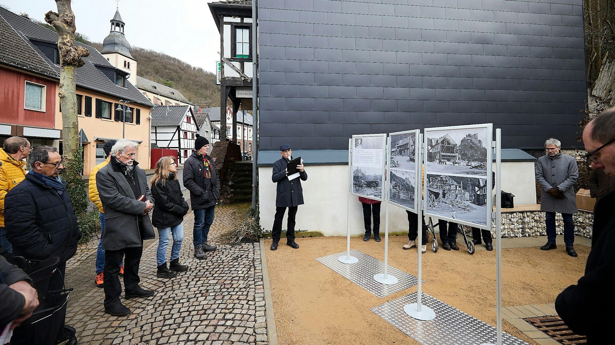 Einige Menschen stehen in Heimbach vor Stellwänden, auf denen alte Fotos zu sehen sind.
