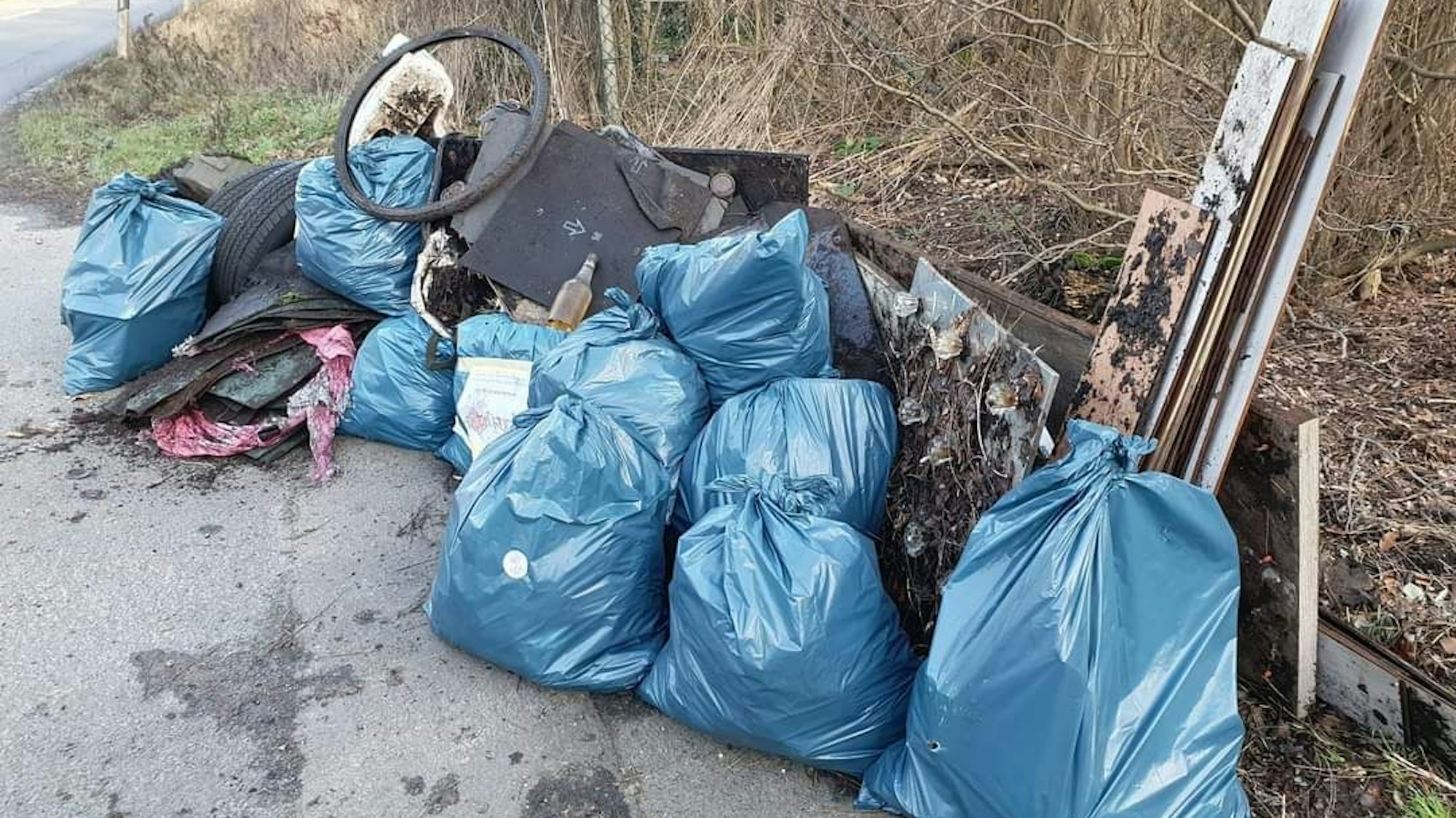 Auf dem Bild sind volle Müllsäcke und Sperrmüll zu sehen.