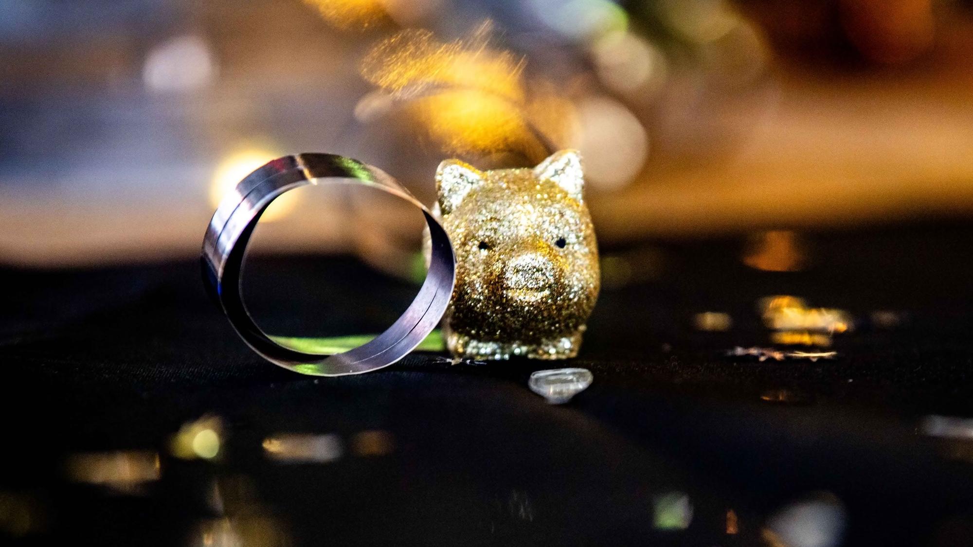Die Detailaufnahme zeigt ein goldenes Miniatur-Glücksschweinchen.