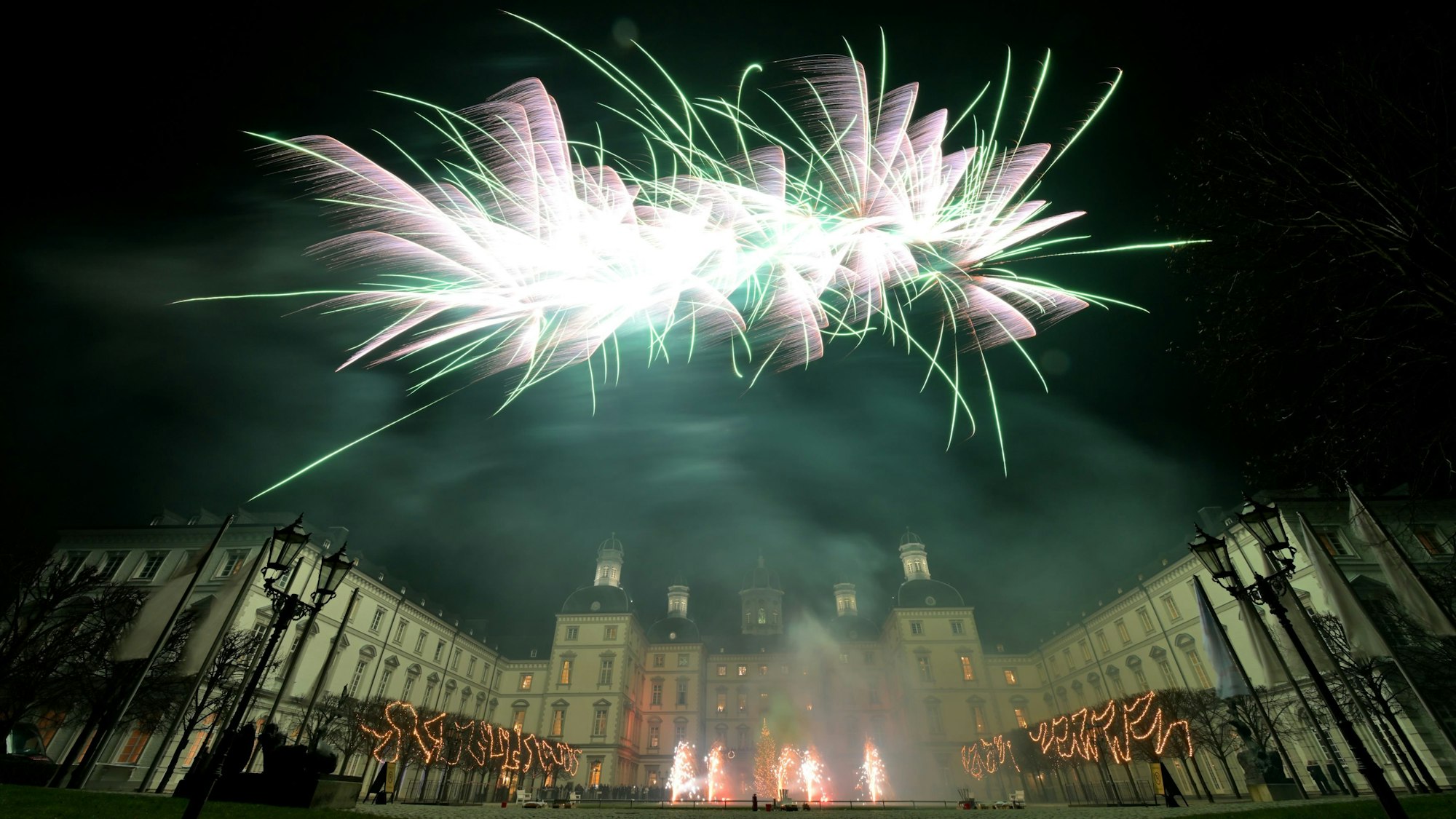 Silvesterraketen am nächtlichen Himmel über Schloss Bensberg.