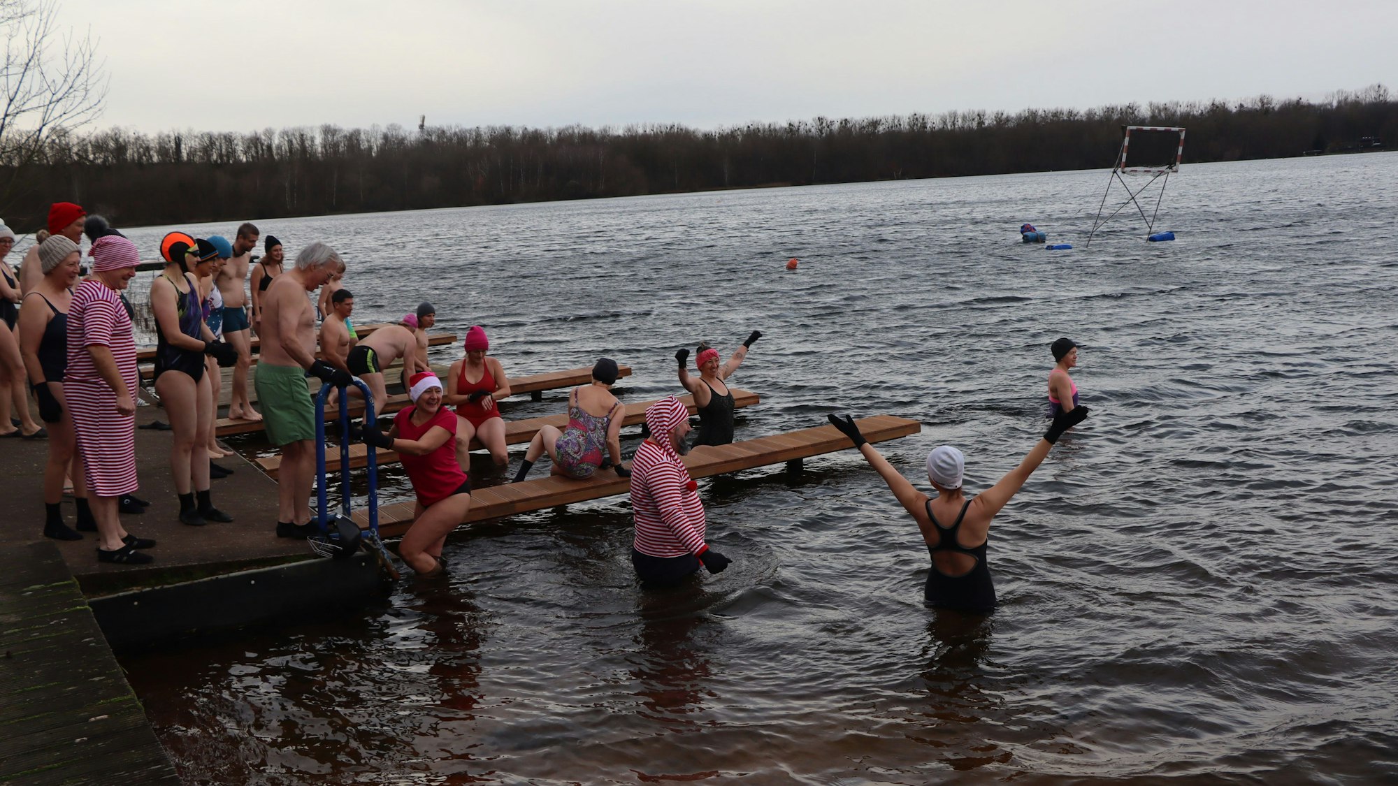 Auf dem Bild sind Menschen zu sehen, die in einem See baden.