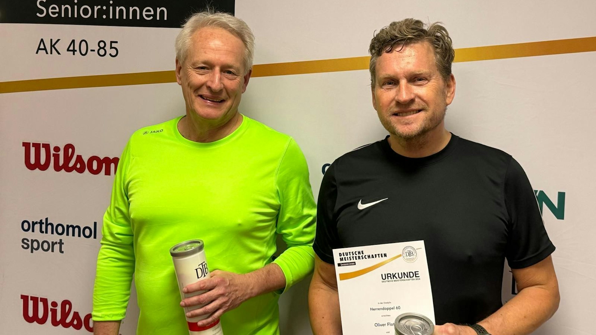 Oliver Flotho (rechts) strahlt mit seiner Urkunde in der Hand.