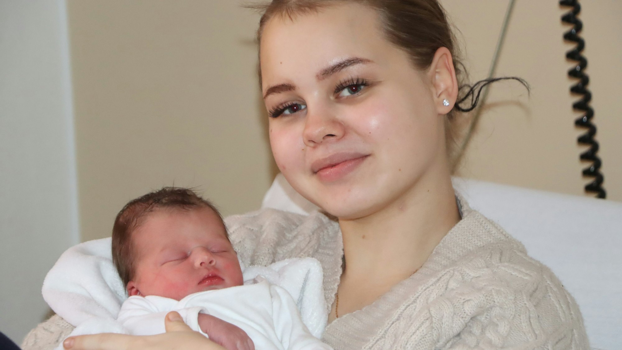 Auf dem Bild ist eine junge Frau mit ihrer neu geborenen Tochter zu sehen.